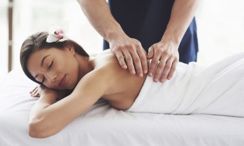 Beautiful young woman relaxing with hand massage at beauty spa